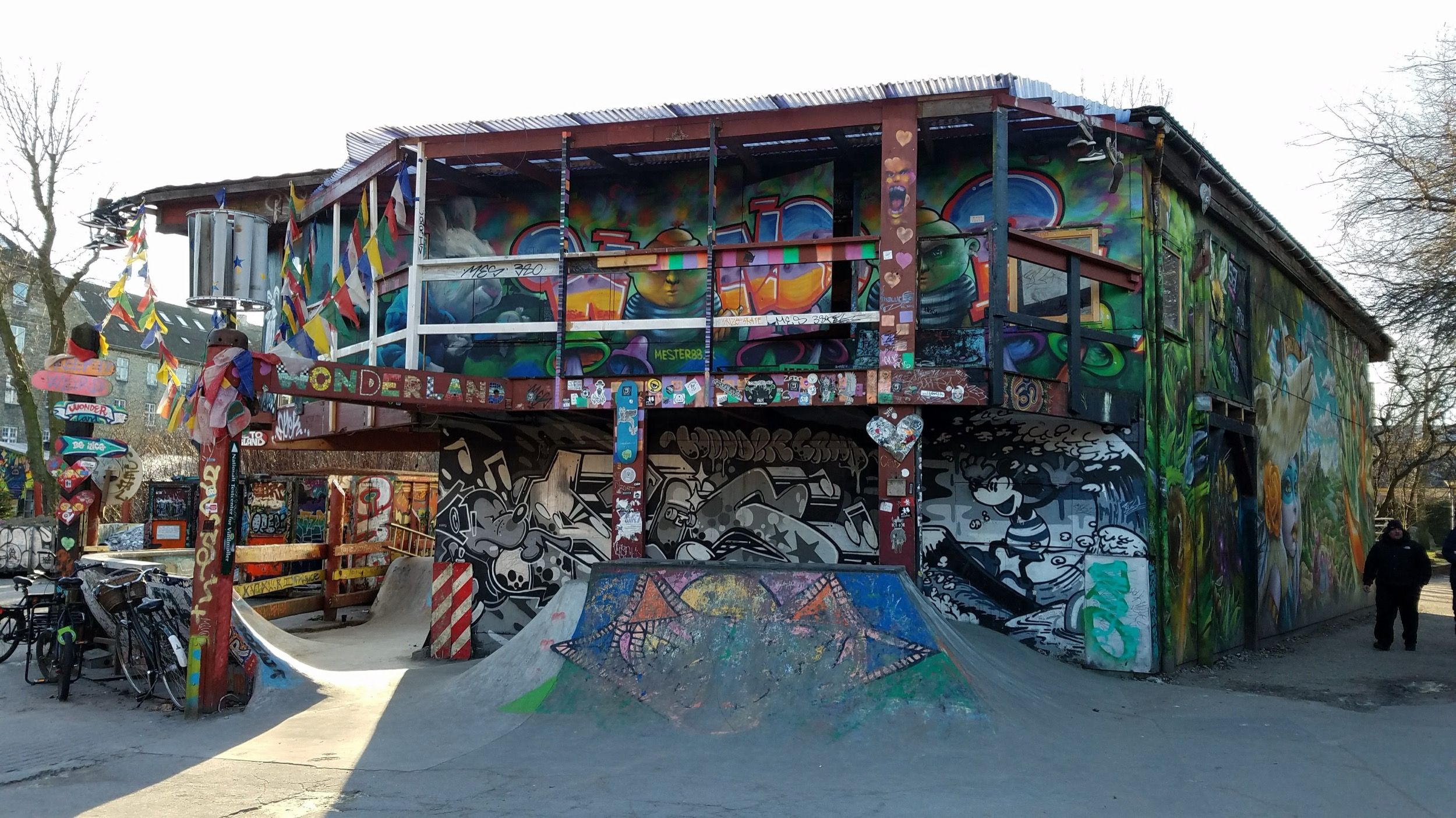 Buntes Graffiti-Gebaeude mit Skateboard-Rampe in der Freistadt Christiania, dem alternativen Stadtteil Kopenhagens.