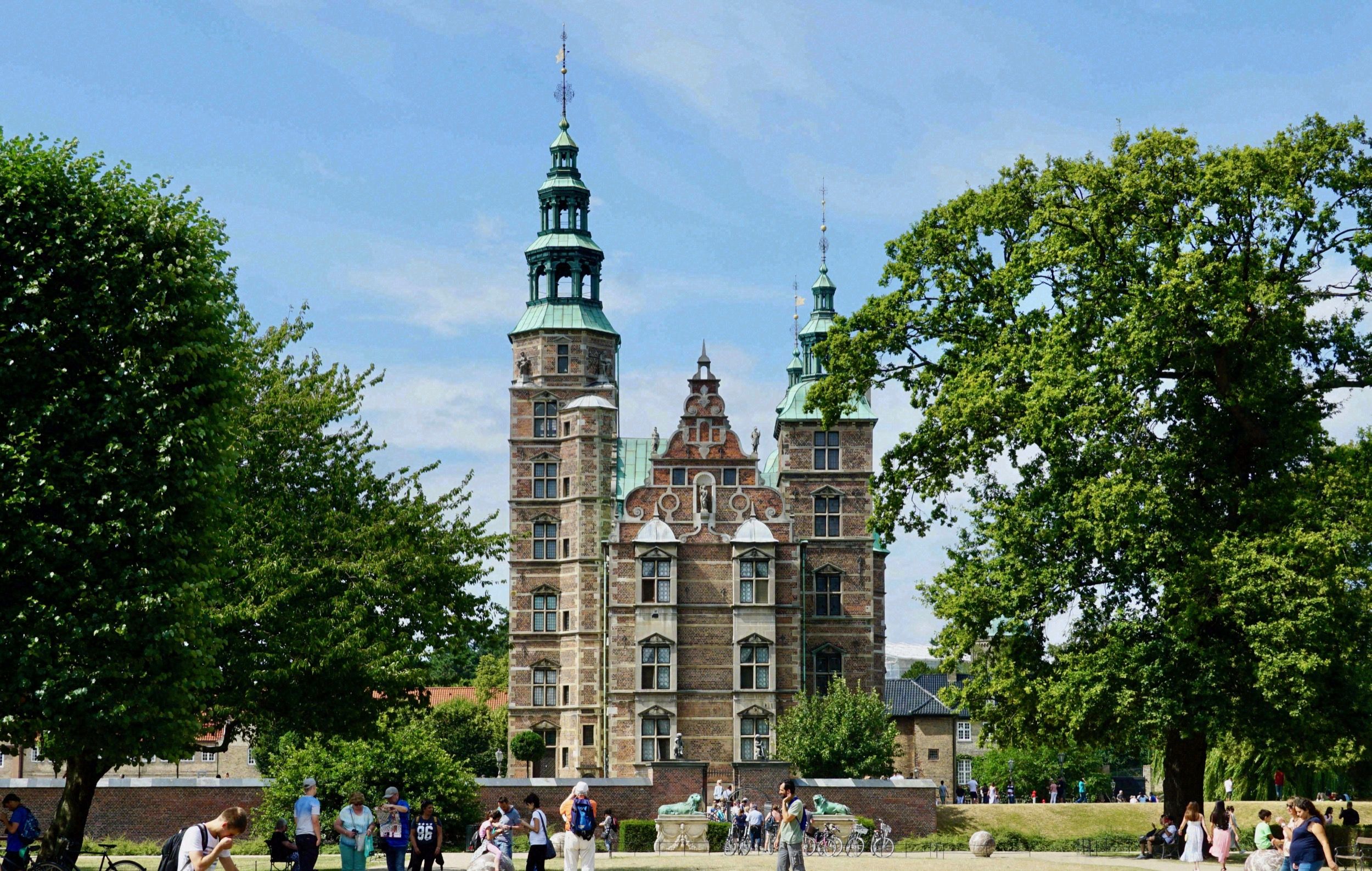 Frontansicht des imposanten roten Backsteingebaeudes des Kopenhagener Rathauses (Radhus) mit seinem markanten Uhrturm.